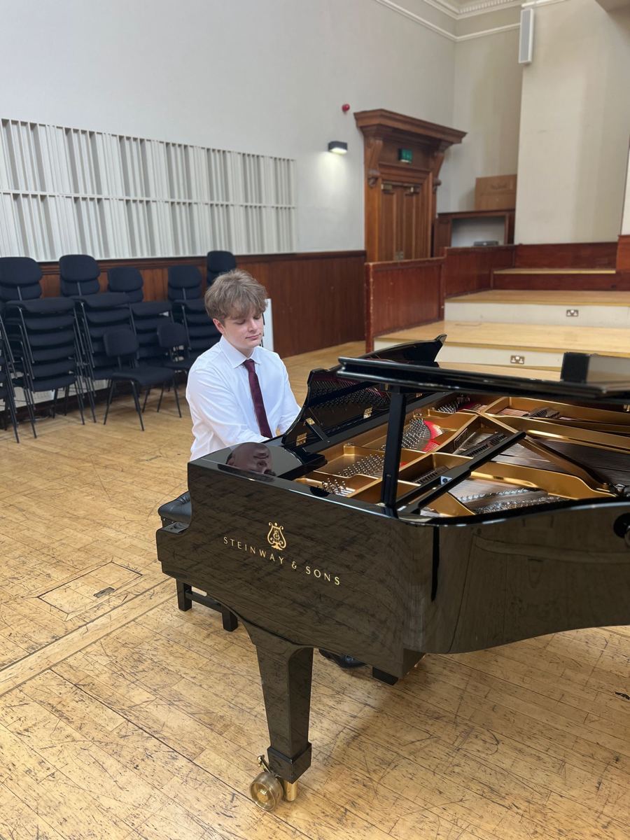 David Dugnas at a Steinway grand piano in a concert hall