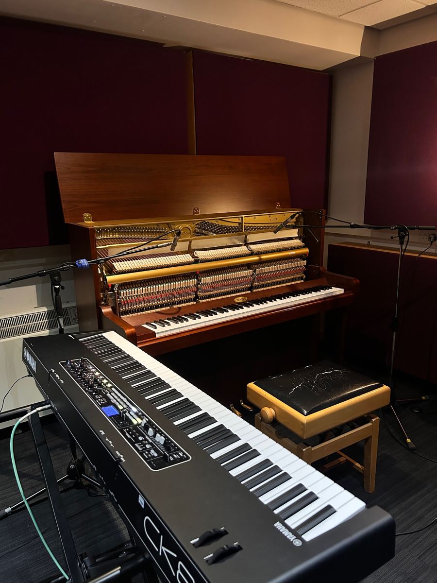 Recording studio with an upright piano, microphones and a Yamaha CK88 stage keyboard